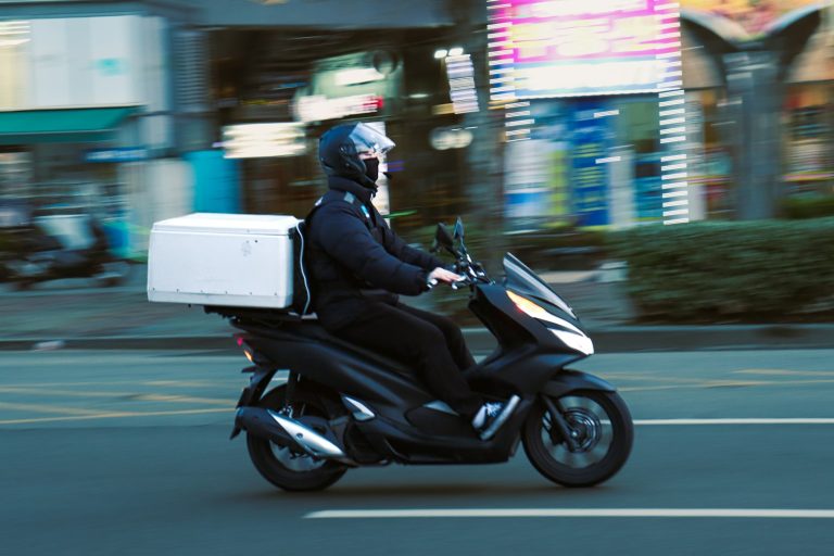 Repartidor en scooter con caja de entrega, representando el servicio de delivery de productos para mascotas
